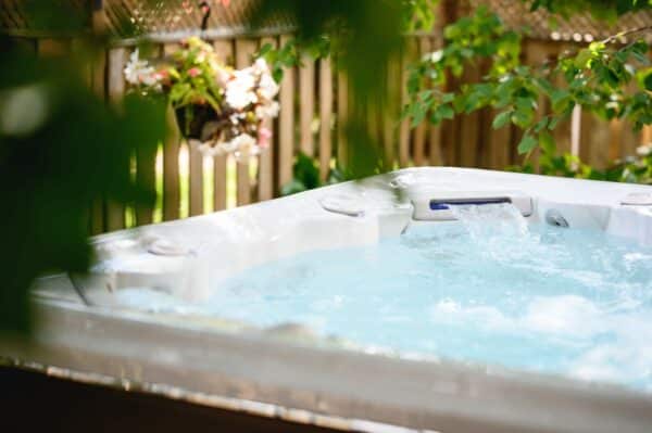 Lifestyle image of Hydropool Signature 720 Platinum internal waterfall with plants in the foreground